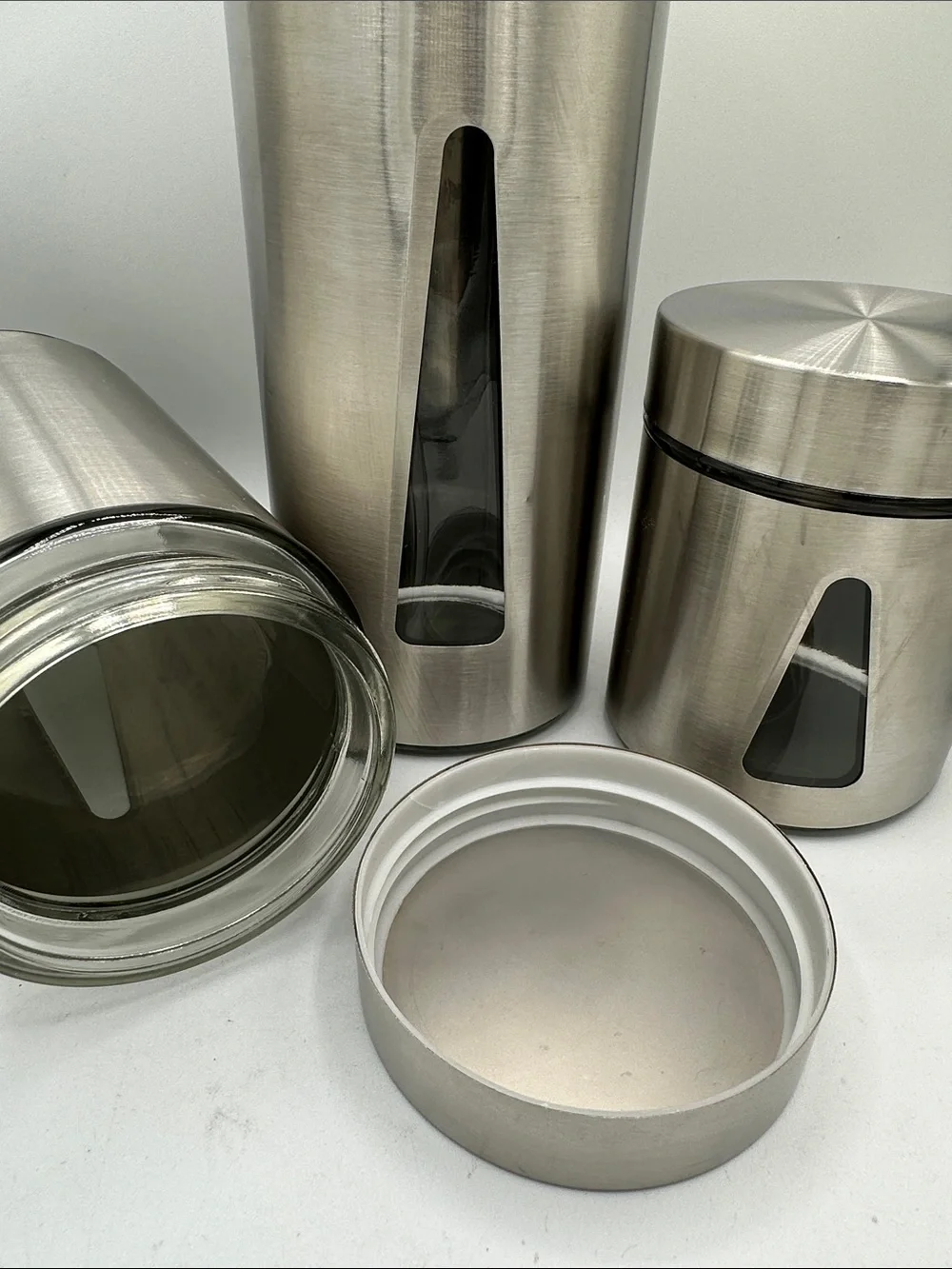 Three-piece steel and glass canister set with triangular viewing windows